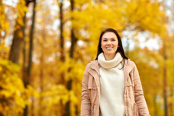 Image showing beautiful happy young woman smiling in autumn park