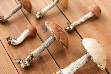 Image showing brown cap boletus mushrooms on wooden background