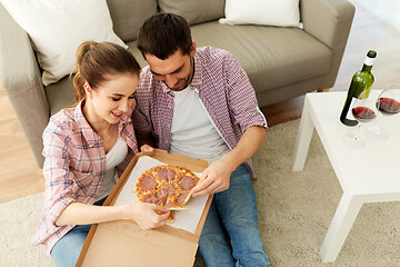 Image showing couple with red wine eating takeaway pizza at home