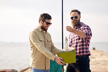 Image showing friends with fish, bucket and fishing rod on pier