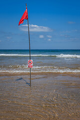 Image showing Red flag on the beach. Swimming and surfing ban.