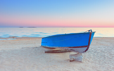 Image showing Pink Sunset Seascape With A Blue Fishing Boat On A Beach