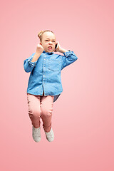 Image showing Young happy caucasian teen girl jumping with phone in the air, isolated on pink studio background.