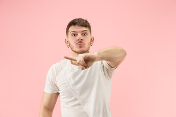 Image showing Beautiful male half-length portrait isolated on pink studio backgroud. The young emotional surprised man