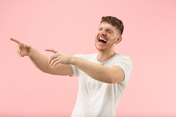 Image showing The happy business man standing and smiling against pink background.