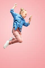 Image showing Young happy caucasian teen girl jumping with phone in the air, isolated on pink studio background.