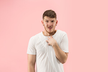 Image showing Beautiful male half-length portrait isolated on pink studio backgroud. The young emotional surprised man