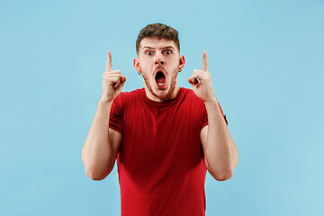 Image showing The young attractive man looking suprised isolated on blue