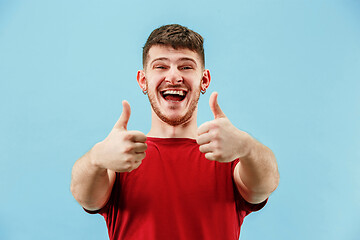 Image showing The happy businessman standing and smiling against blue background.