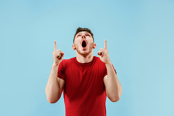 Image showing The young attractive man looking suprised isolated on blue