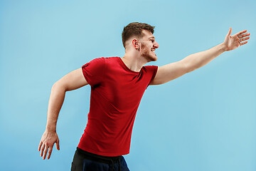 Image showing Isolated on pink young casual man shouting at studio