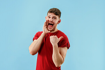 Image showing Isolated on pink young casual man shouting at studio