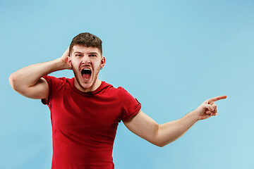 Image showing Isolated on pink young casual man shouting at studio