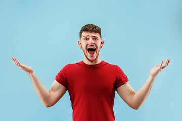 Image showing The young attractive man looking suprised isolated on blue