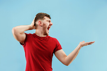 Image showing Isolated on pink young casual man shouting at studio