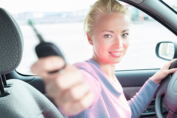 Image showing Female driver showing car keys. Young female driving happy about her new car or drivers license.