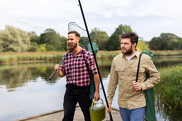 Image showing male friends with net and fishing rods on lake