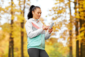 Image showing woman in autumn park and listening to music