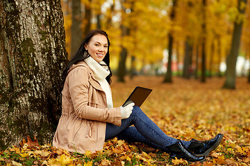 Image showing woman with tablet computer at autumn park