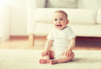 Image showing happy baby boy or girl sitting on floor at home