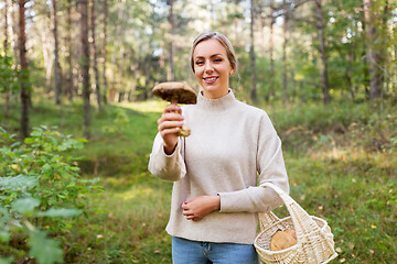 Image showing young woman with mushroom in autumn forest