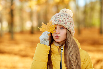 Image showing portrait of girl with maple leaf at autumn park