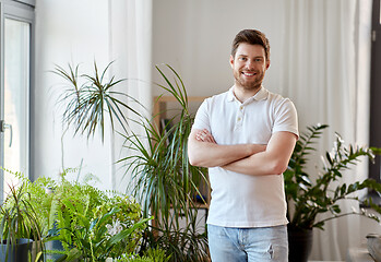 Image showing smiling man with houseplants at home