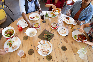 Image showing international friends eating at restaurant