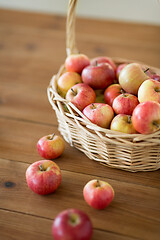 Image showing ripe apples in wicker basket on wooden table