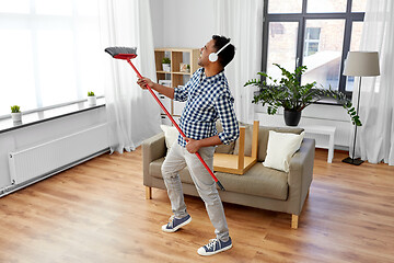 Image showing man with broom cleaning and having fun at home