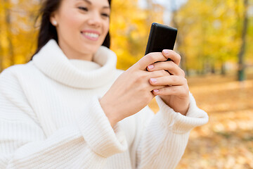 Image showing woman using smartphone in autumn park