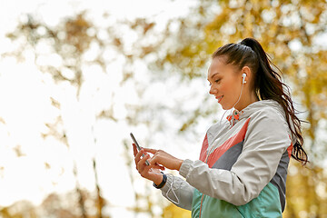 Image showing woman in autumn park and listening to music