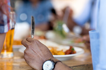 Image showing african man eating with friends at restaurant