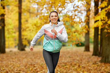 Image showing young woman running in autumn park