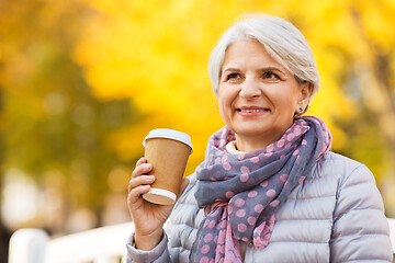 Image showing senior woman drinking coffee in autumn park