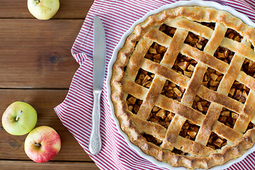 Image showing close up of apple pie in baking mold and knife