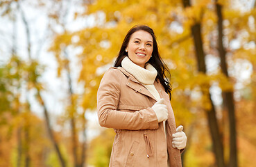 Image showing beautiful happy young woman smiling in autumn park