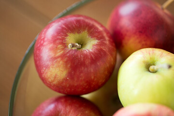 Image showing ripe apples in glass bowl on wooden table