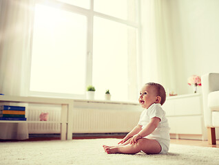 Image showing happy baby boy or girl sitting on floor at home