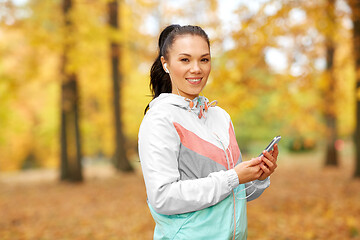 Image showing woman in autumn park and listening to music