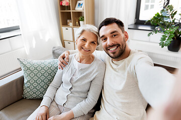 Image showing senior mother with adult son taking selfie at home