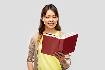 Image showing happy asian woman reading book