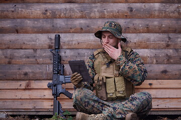 Image showing soldier using tablet computer in military camp