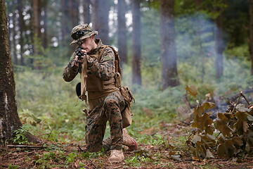 Image showing soldier in action aiming  on weapon  laser sight optics