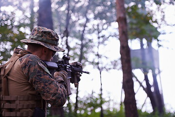 Image showing soldier in action aiming  on weapon  laser sight optics