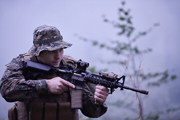 Image showing soldier in action aiming  on weapon  laser sight optics