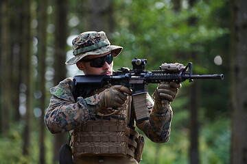 Image showing soldier in action aiming  on weapon  laser sight optics