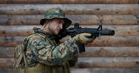 Image showing soldier in action aiming  on weapon  laser sight optics