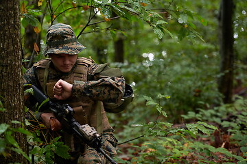 Image showing soldier preparing tactical and commpunication gear for action ba