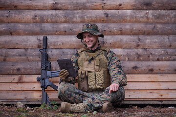 Image showing soldier using tablet computer in military camp